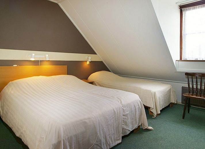 Gemtliches Wohnzimmer im Ferienhaus West, Buren, Ameland mit Ledermbeln und groen Fenstern fr viel Tageslicht.