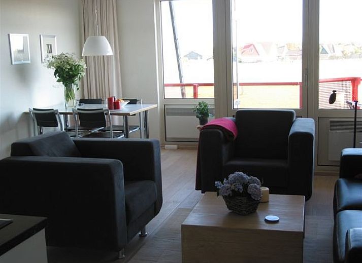 Frontansicht der Wohnung Amelander Paradise in Buren, Ameland, mit Fahnen und gruener Umgebung.