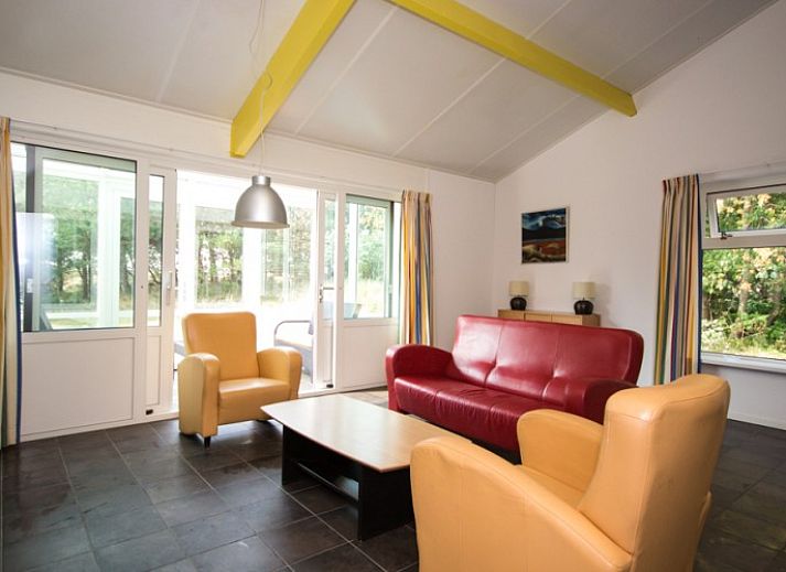 Cozy living room of Bungalow 18 in Buren, Ameland with colorful furniture and views of nature.
