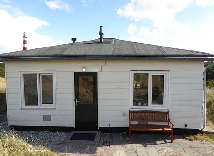 Vakantiehuisje in Hollum op Ameland met uitzicht op de vuurtoren, ideaal voor een ontspannen verblijf op de Waddeneilanden.
