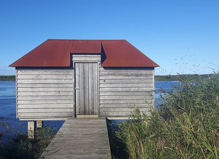 Gezellige woonkamer van Vakantiehuisje in Hollum op Ameland met comfortabele meubels en uitzicht op de natuur.