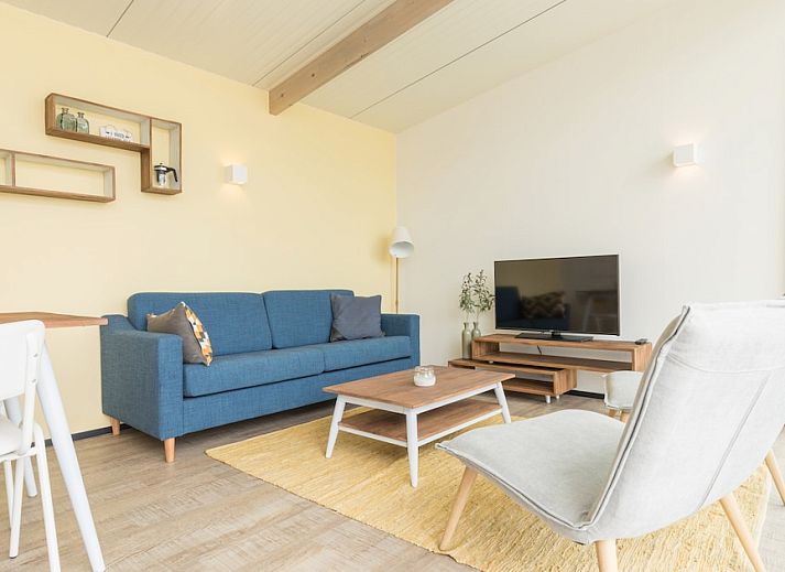 Kooikers Comfort vakantiehuis in Hollum, Ameland, Waddeneilanden met moderne veranda en zandige omgeving.
