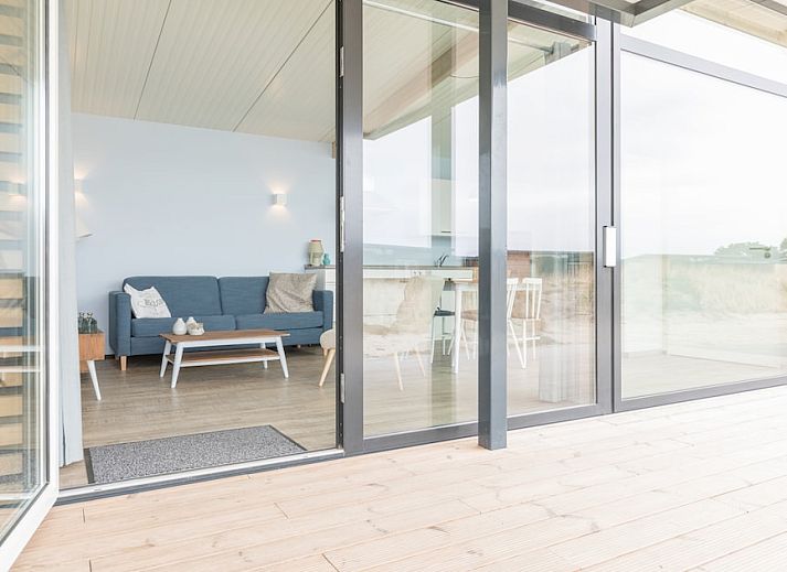 Gezellige woonkamer in Wadden Special vakantiehuis in Hollum, Ameland met moderne inrichting en comfortabele zithoek.