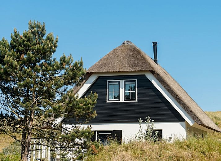 Engelsmanduinvilla 8 in Hollum, Ameland, een charmant vakantiehuis met rieten dak, omgeven door natuur in de Waddeneilanden.