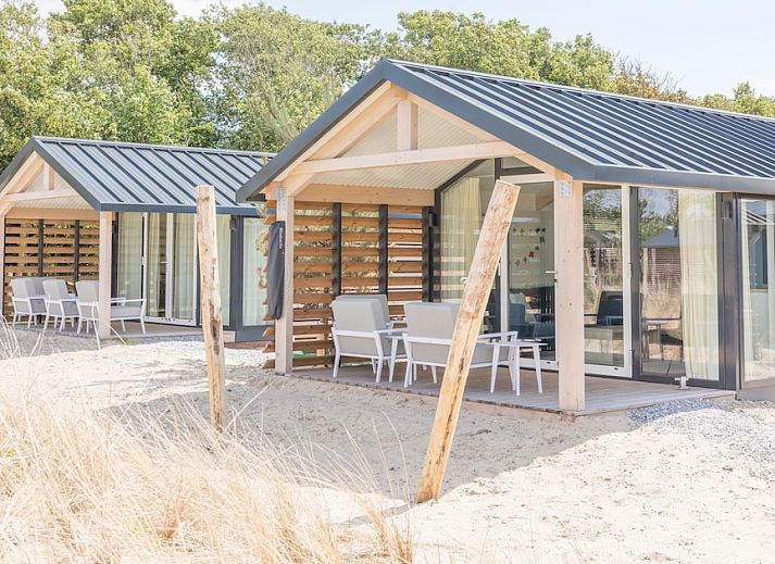 Lichte woonkamer van Lighthouse Adventure vakantiehuis in Hollum, Ameland, met uitzicht op de natuur.
