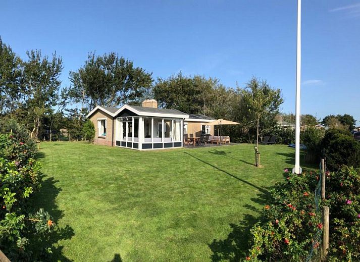 Spacious lawn with terrace at vacation home Strandloper in Hollum, Ameland, Wadden Islands.