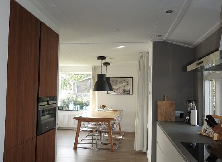 Sunny garden with flagpole at Strandloper vacation home, Hollum, Ameland.
