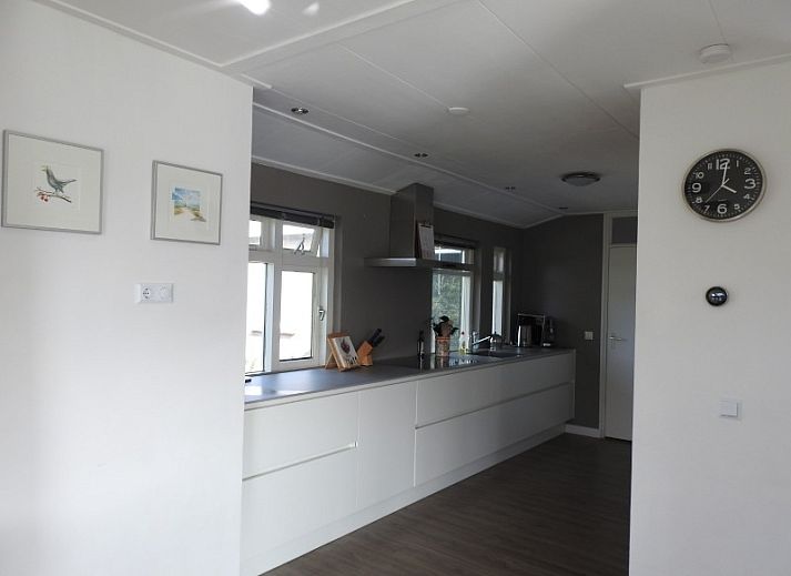 Sunny garden with flagpole at Strandloper vacation home, Hollum, Ameland.