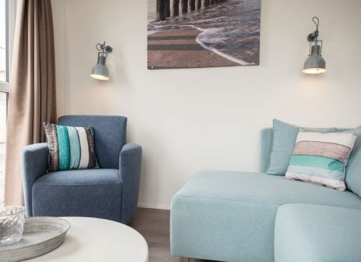 Gemuetliches Wohnzimmer der VUURTORENLODGE 6 in Hollum, Ameland, mit moderner Einrichtung und viel natuerlichem Licht.