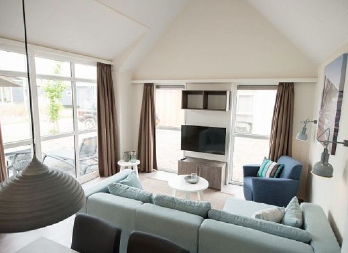 Gemuetliches Wohnzimmer der VUURTORENLODGE 6 in Hollum, Ameland, mit moderner Einrichtung und viel natuerlichem Licht.