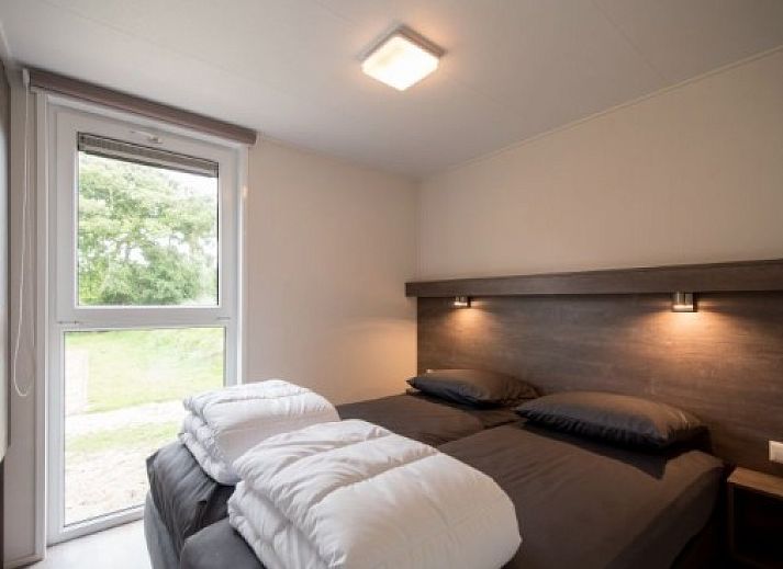 Gemuetliches Wohnzimmer der VUURTORENLODGE 6 in Hollum, Ameland, mit moderner Einrichtung und viel natuerlichem Licht.