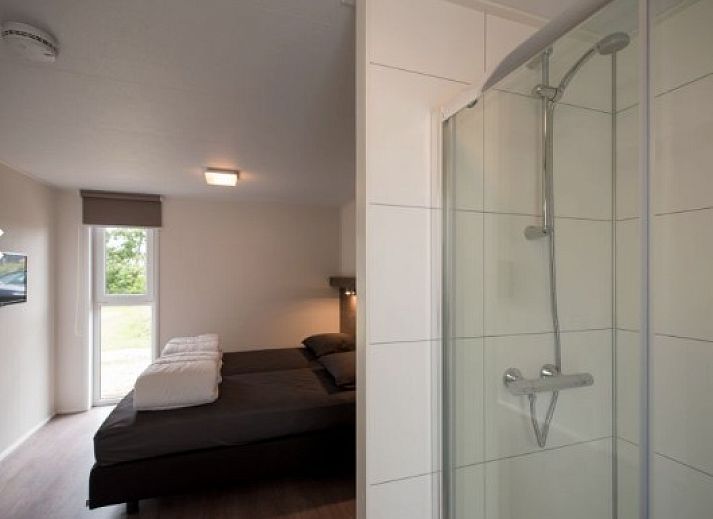 Gemuetliches Wohnzimmer der VUURTORENLODGE 6 in Hollum, Ameland, mit moderner Einrichtung und viel natuerlichem Licht.