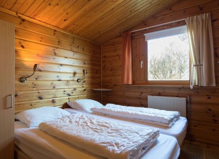 Exterior view of FINSE BUNGALOW 6 in Hollum, Ameland, with terrace and green surroundings on the Wadden Islands.