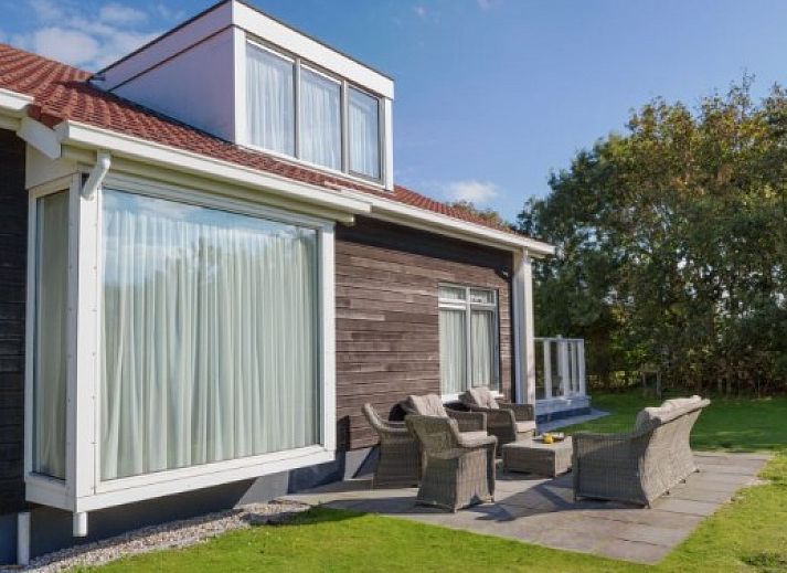 Gezellige binnenruimte van DUINBUNGALOW 10 in Hollum, Ameland, met comfortabele zithoek en veel natuurlijk licht.