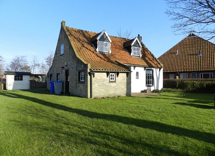 Vacation home Kiewiet Ameland in Hollum offers a charming white facade with red roof tiles, ideal for a relaxing stay on the Wadden Islands.