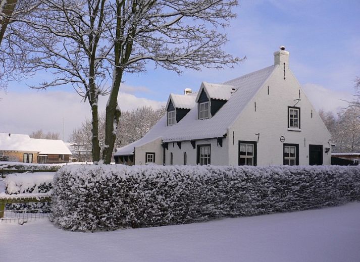 Vacation home Kiewiet Ameland in Hollum offers a charming white facade with red roof tiles, ideal for a relaxing stay on the Wadden Islands.