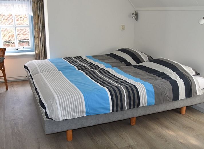 The natural setting of Holiday home Kiewiet Ameland in Hollum offers peace and privacy, surrounded by green trees and a flowering garden.