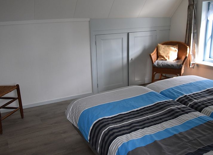 The natural setting of Holiday home Kiewiet Ameland in Hollum offers peace and privacy, surrounded by green trees and a flowering garden.