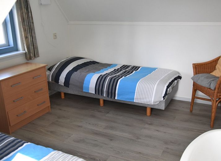 The natural setting of Holiday home Kiewiet Ameland in Hollum offers peace and privacy, surrounded by green trees and a flowering garden.