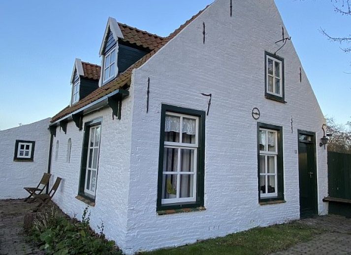 The natural setting of Holiday home Kiewiet Ameland in Hollum offers peace and privacy, surrounded by green trees and a flowering garden.