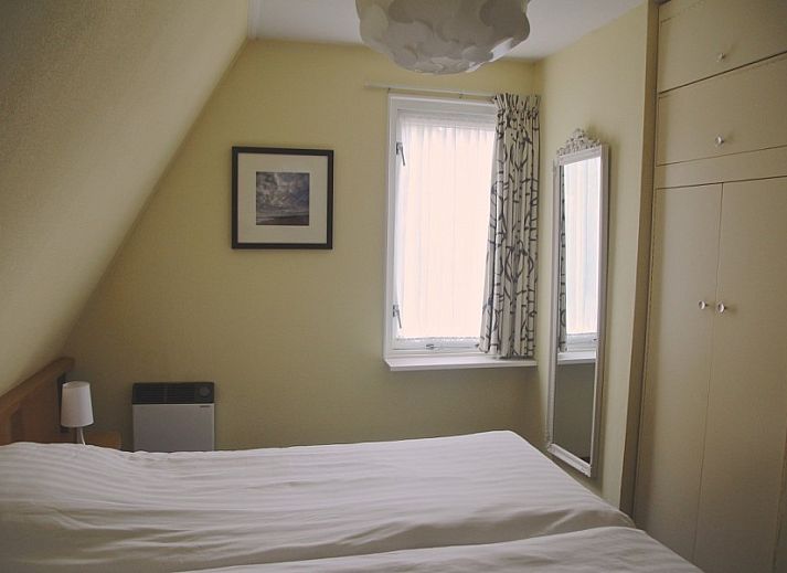 Gemuetliches Wohnzimmer in der Ferienwohnung Amelander Kaap 2, Hollum, Ameland mit bequemem Sofa und viel Tageslicht.