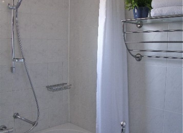 Gemuetliches Wohnzimmer in der Ferienwohnung Amelander Kaap 2, Hollum, Ameland mit bequemem Sofa und viel Tageslicht.