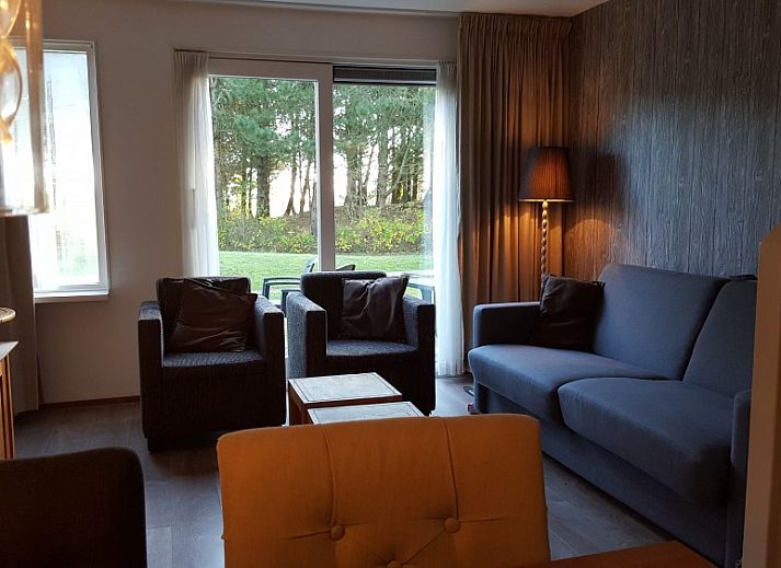 Essecke mit Holztisch und moderner Kueche in der Ferienwohnung Amelander Kaap 2, Hollum, Ameland, ideal fuer gemuetliche Mahlzeiten.