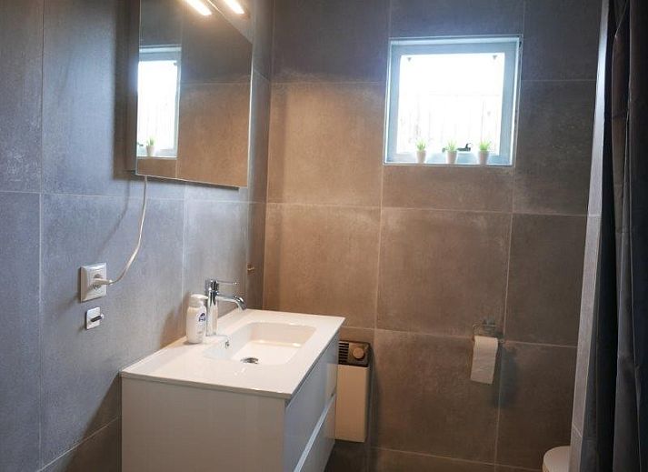 Essecke mit Holztisch und moderner Kueche in der Ferienwohnung Amelander Kaap 2, Hollum, Ameland, ideal fuer gemuetliche Mahlzeiten.