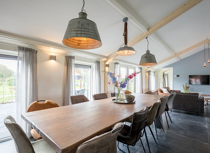 Geraeumiges Wohnzimmer im Bungalow Wagenschuur in Hollum, Ameland, mit moderner Einrichtung und Blick auf die Watteninseln.