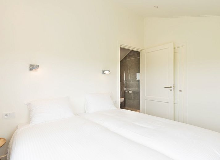 Innenraum mit Holzschiebetuer und Spiegel im Bungalow Wagenschuur, Hollum, Ameland, Watteninseln.