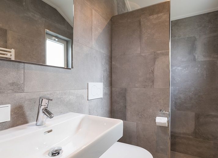 Innenraum mit Holzschiebetuer und Spiegel im Bungalow Wagenschuur, Hollum, Ameland, Watteninseln.