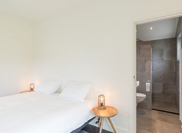 Innenraum mit Holzschiebetuer und Spiegel im Bungalow Wagenschuur, Hollum, Ameland, Watteninseln.