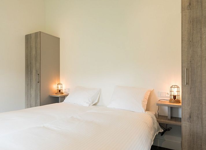 Gemuetliches Esszimmer im Bungalow Wagenschuur, Hollum, Ameland mit langem Tisch und Blick auf die Natur.