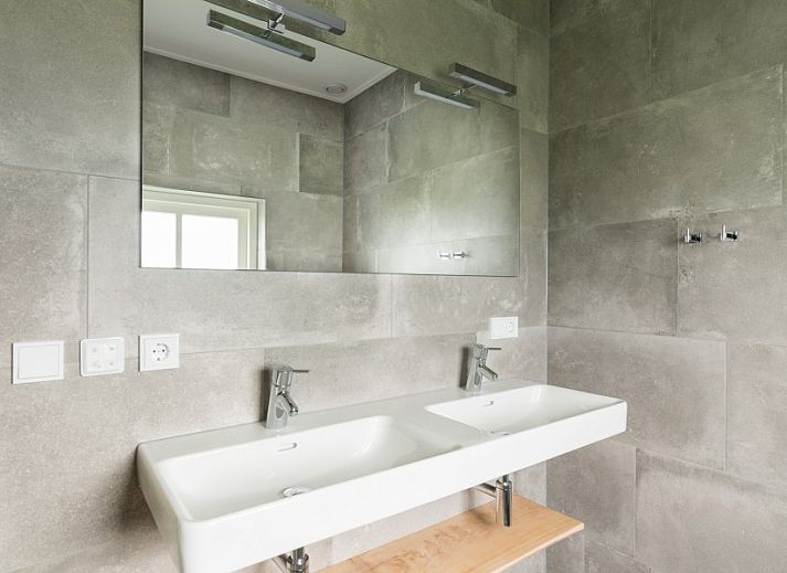 Gemuetliches Esszimmer im Bungalow Wagenschuur, Hollum, Ameland mit langem Tisch und Blick auf die Natur.