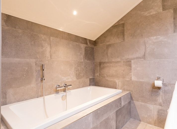 Gemuetliches Esszimmer im Bungalow Wagenschuur, Hollum, Ameland mit langem Tisch und Blick auf die Natur.