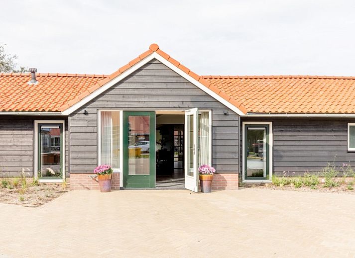 Heller Essbereich im Ferienhaus Wagenschuur, Hollum, Ameland mit grossen Fenstern und moderner Beleuchtung.