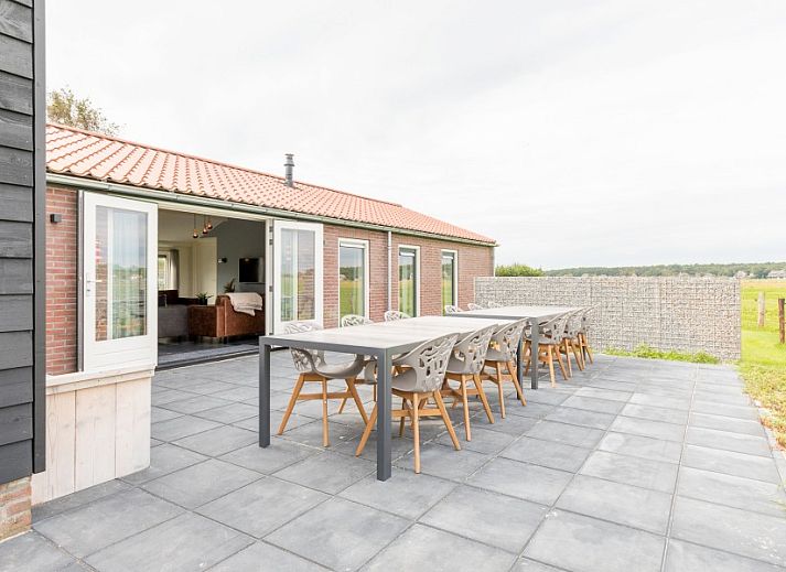 Heller Essbereich im Ferienhaus Wagenschuur, Hollum, Ameland mit grossen Fenstern und moderner Beleuchtung.