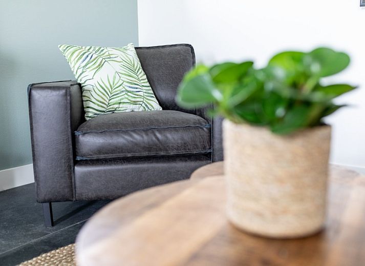 Stijlvolle eetkamer van De Deel, vakantieappartement in Hollum, Ameland, met houten tafel en designverlichting.