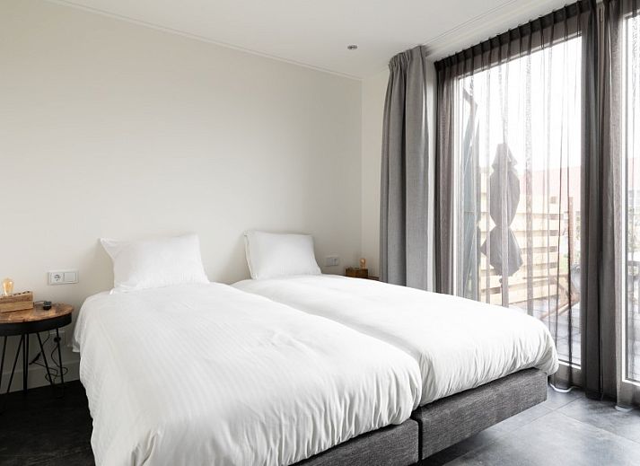 Stijlvolle eetkamer van De Deel, vakantieappartement in Hollum, Ameland, met houten tafel en designverlichting.