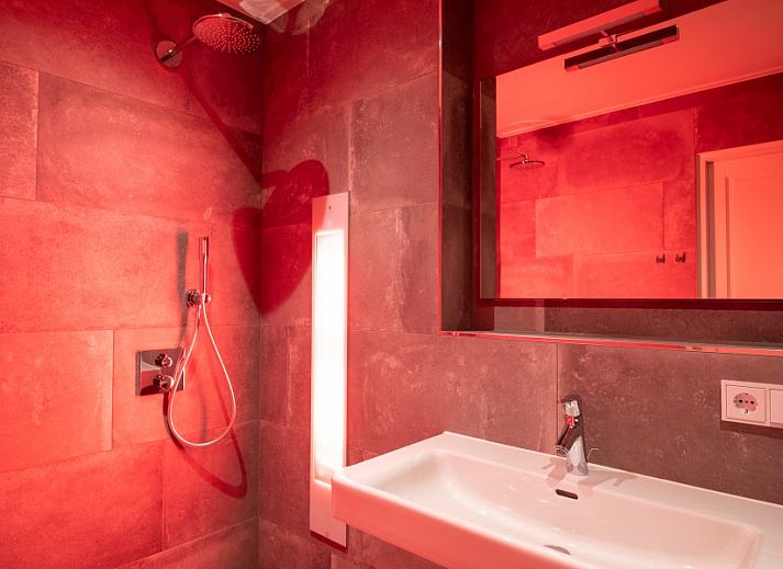 Moderne keuken in De Deel, appartement in Hollum, Ameland, met strakke houten kasten en veel lichtinval.