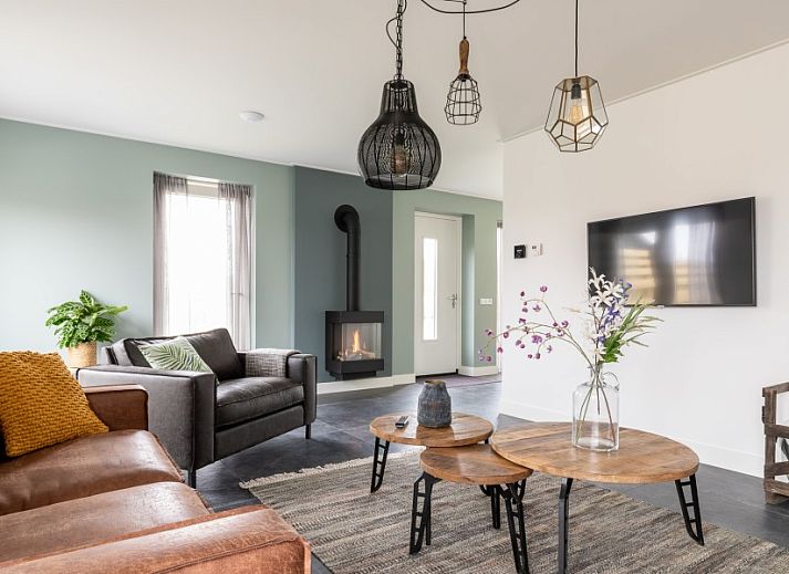 Stilvolles Wohnzimmer in der Wohnung Dwarsdeel, Hollum, Ameland mit Ledersofas und moderner Beleuchtung.