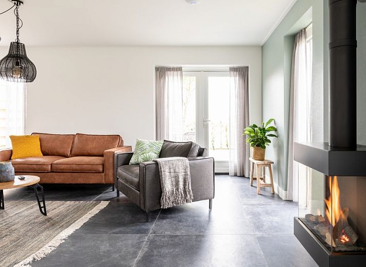 Stilvolles Wohnzimmer in der Wohnung Dwarsdeel, Hollum, Ameland mit Ledersofas und moderner Beleuchtung.