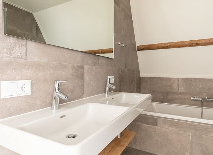 Geraeumiges Wohnzimmer mit viel Licht in der Ferienwohnung Dwarsdeel, Hollum, Ameland.