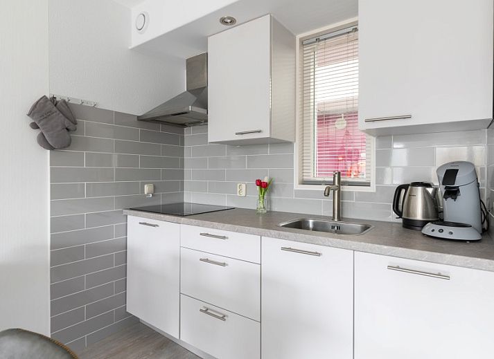 Komfortables Wohnzimmer des Amelander Kaap 126 in Hollum, Ameland, mit gemuetlichem Sofa und moderner Einrichtung.