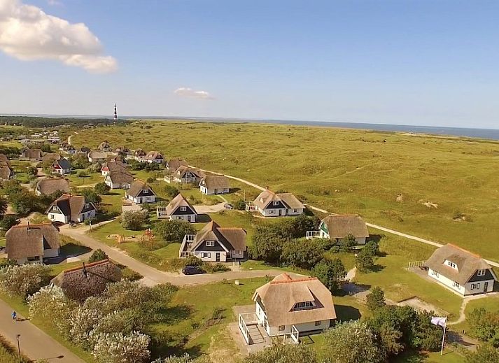 Vorderseite des Sartorius Ferienhauses in Hollum, Ameland mit grosszuegiger Auffahrt und gruener Umgebung auf den Watteninseln.