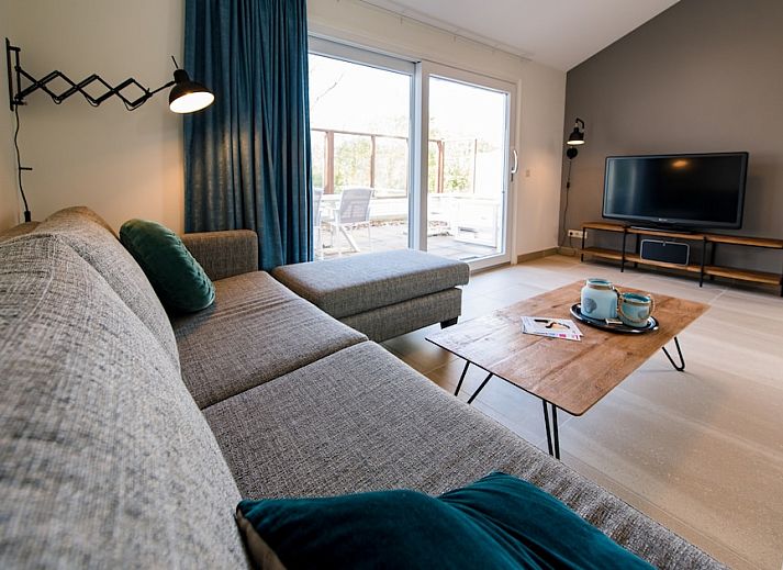 Ontspan op het terras van Bornrif Luxe 6, een moderne bungalow in Hollum, Ameland, omringd door weelderige natuur op de Waddeneilanden.