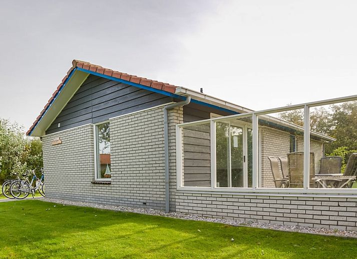 Ontspan op het terras van Bornrif Luxe 6, een moderne bungalow in Hollum, Ameland, omringd door weelderige natuur op de Waddeneilanden.