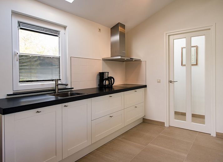 Bornrif Luxe 6 bungalow in Hollum, Ameland met modern terras en comfortabele zitplaatsen, omgeven door groene natuur op de Waddeneilanden.