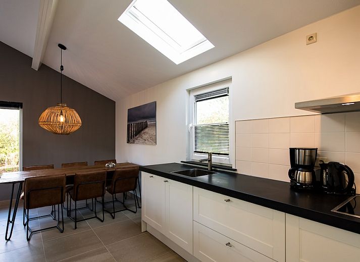 Bornrif Luxe 6 bungalow in Hollum, Ameland met modern terras en comfortabele zitplaatsen, omgeven door groene natuur op de Waddeneilanden.