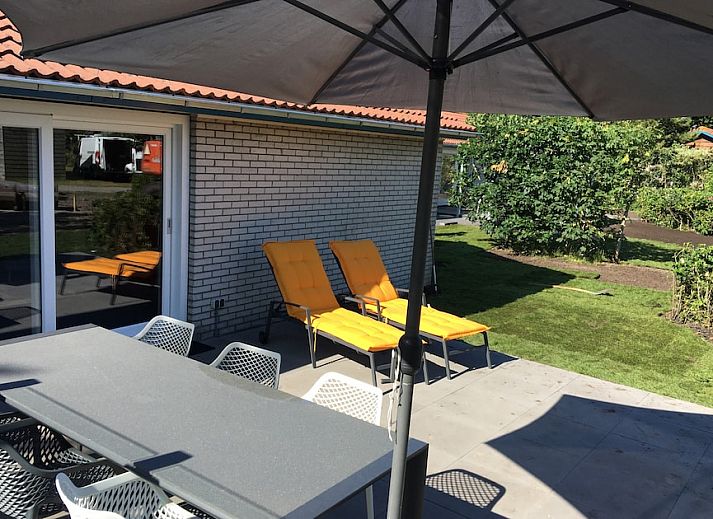 Bornrif Luxe 6 bungalow in Hollum, Ameland met modern terras en comfortabele zitplaatsen, omgeven door groene natuur op de Waddeneilanden.